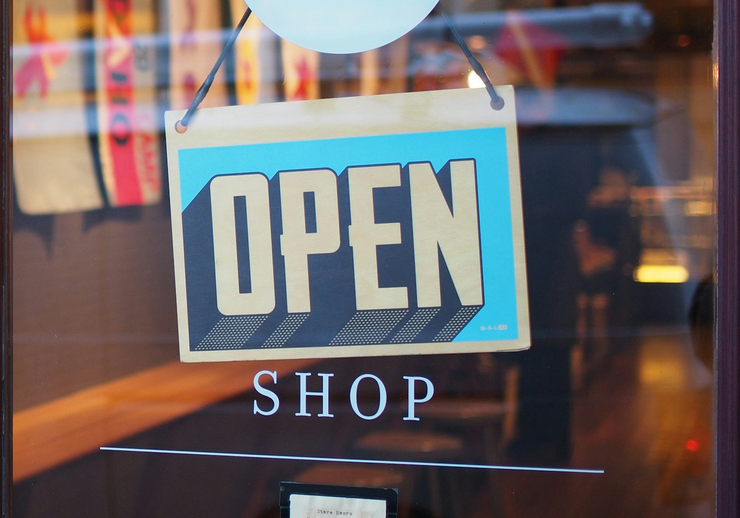 Insegna OPEN appesa alla porta a vetri di un negozio